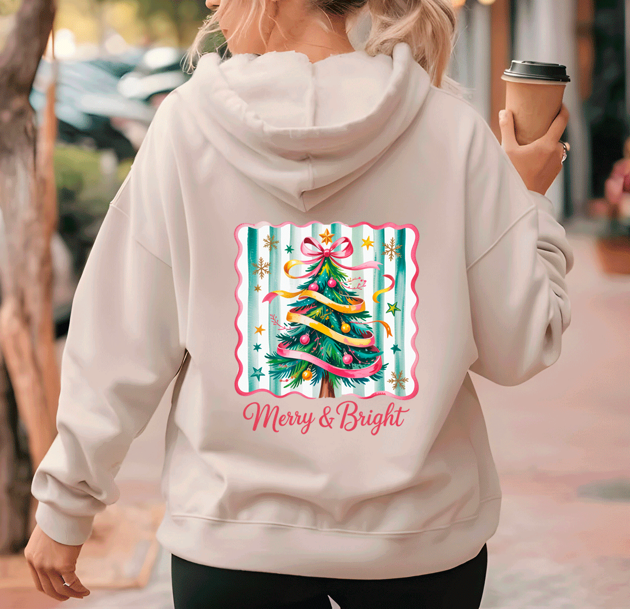 Person wearing a hoodie with a Christmas tree design and 'Merry & Bright' text.