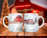 Two Christmas-themed mugs with a red barn and snow scene on a wooden surface.