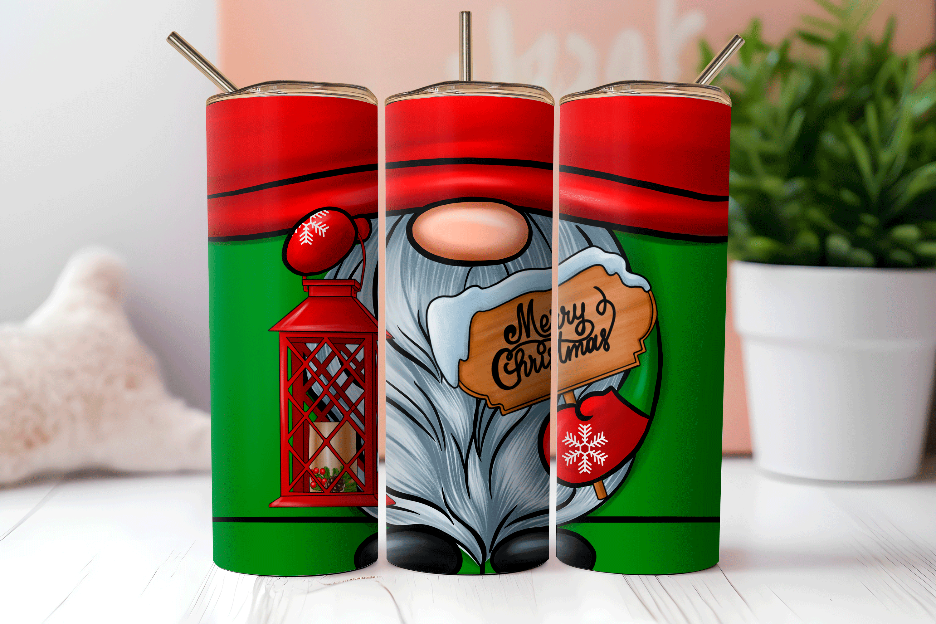 Three Christmas-themed tumblers with designs on a white surface.