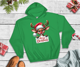 Green hoodie with a reindeer design and 'Merry Christmas' text on a wooden surface with holiday decorations.