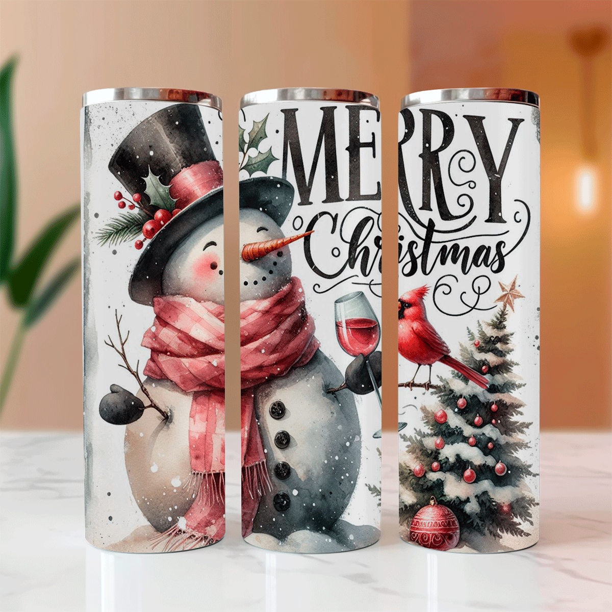 Three Christmas-themed tumblers with snowman, cardinal, and tree designs on a white surface.