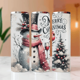 Three Christmas-themed tumblers with snowman, wine glass, and tree designs on a white surface.