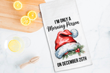 Tea towel with Santa hat and text on a kitchen counter with lemons