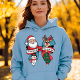 Person wearing a light blue hoodie with Christmas-themed designs in an autumn setting