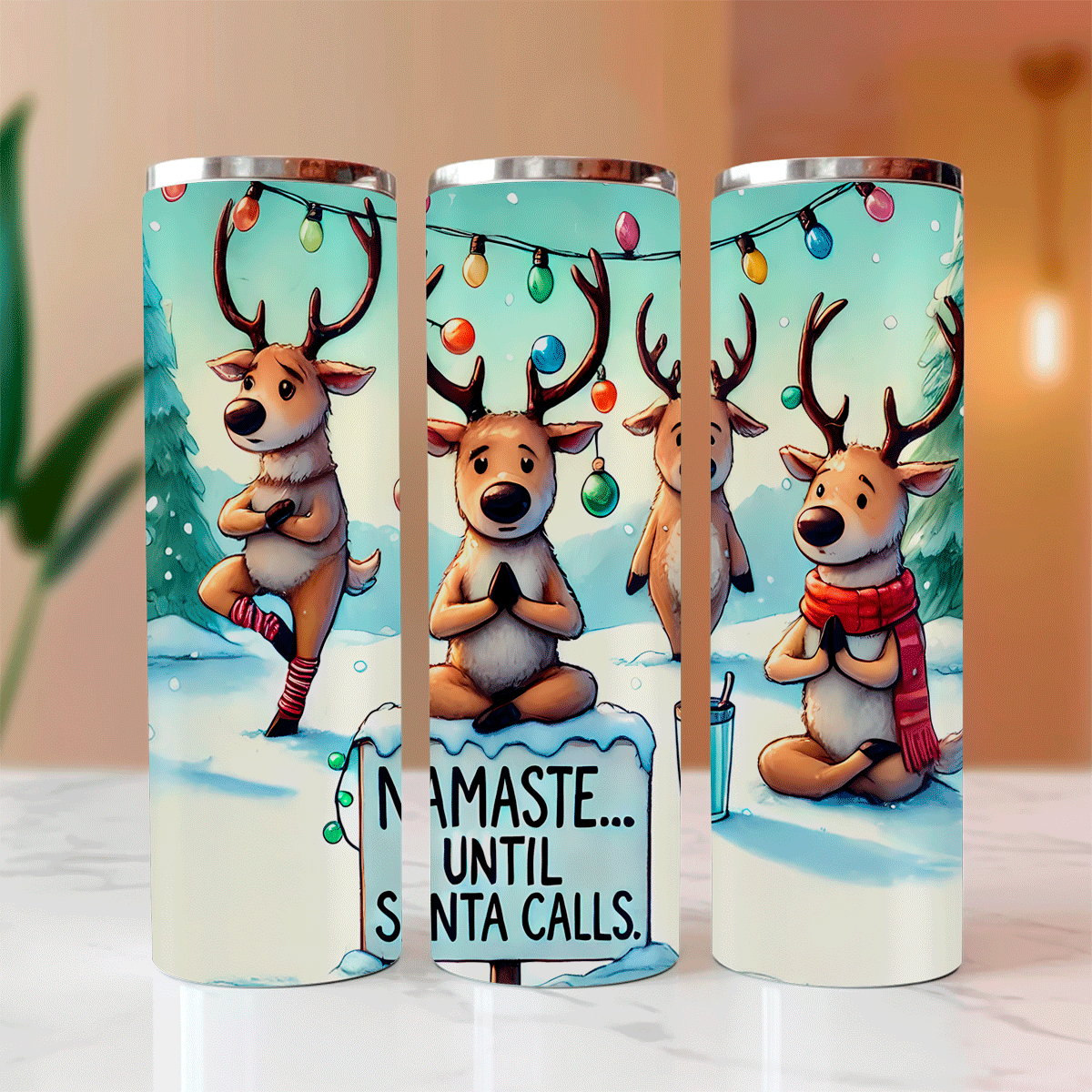 Three tumbler cups with reindeer designs and Christmas-themed text on a light background.