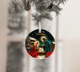 Circular Christmas ornament with a nativity scene design, hanging from a tree.
