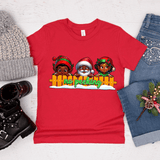 Red t-shirt with Christmas-themed design featuring Santa Claus and two children, surrounded by festive items like a hat, boots, and jeans.