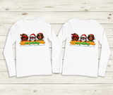 Two white long-sleeve shirts with festive designs on a wooden surface