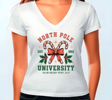 White t-shirt with Christmas-themed design featuring candy canes and a bow, on a plain background.