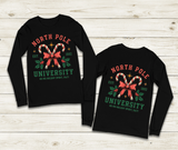 Black long-sleeve shirt with 'North Pole University' design on a wooden surface