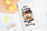 Tea towel with a jar of lights design and text on a kitchen counter with lemons.