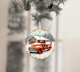 Christmas ornament with a red truck and wreath on a snowy scene, hanging from a tree.