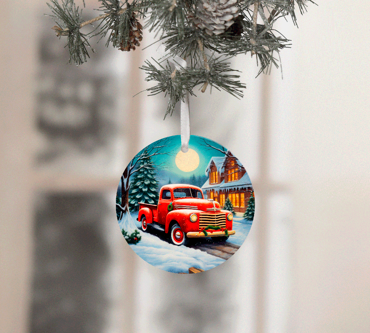 Christmas ornament with a red truck design hanging on a tree branch.