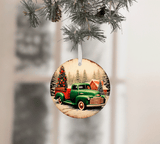 Christmas ornament with a vintage truck and tree design, hanging on a tree branch.