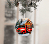 Christmas ornament with a red truck and cabin design, hanging on a tree.