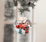 Christmas ornament with a red truck and cabin design, hanging on a tree.