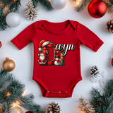 Red baby onesie with Christmas-themed design on a white background with festive decorations.