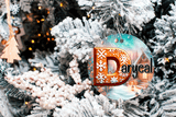 Decorative Christmas ornament with 'Daryca' logo on a tree
