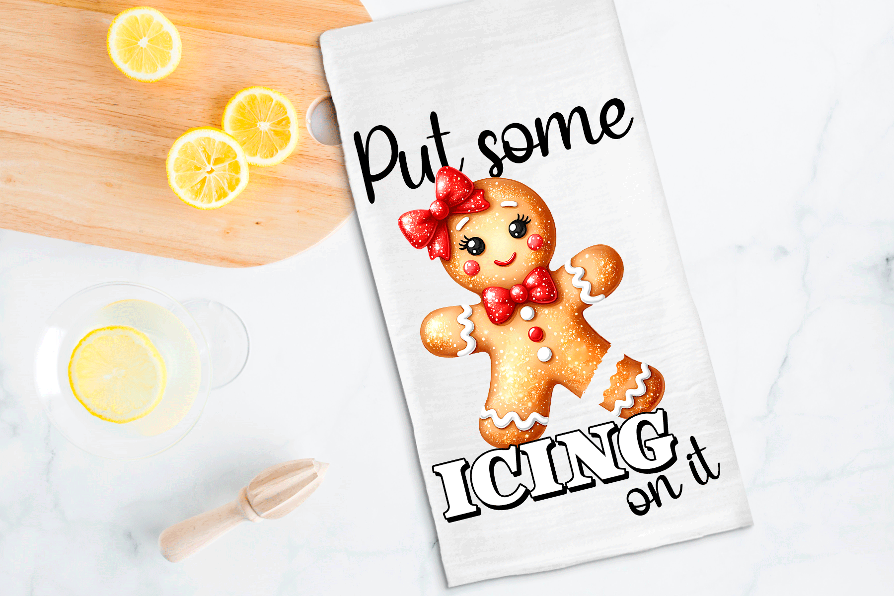 Tea towel with a gingerbread man design and text 'Put some icing on it' on a kitchen counter with lemons.