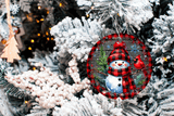 Decorative Christmas ornament with a snowman and plaid pattern on a tree.