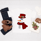 Snowman decoration with plaid hat and scarf, boots, jeans, and a sweater on a white background
