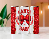 Three tumblers with red glittery designs and 'Santa Baby' text on a blurred indoor background.