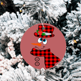 Round Christmas ornament with a snowman design on a tree