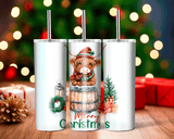 Three white tumblers with Christmas-themed designs on a wooden surface with a festive background.