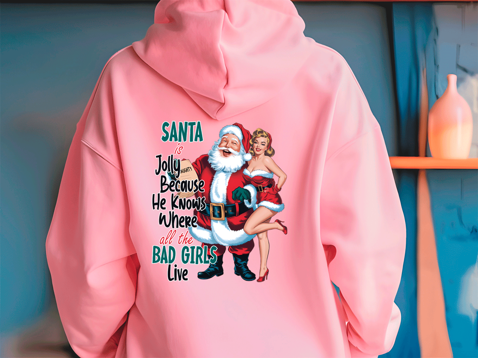 Pink hoodie with a graphic of Santa Claus and a woman, text, and a blue background.