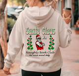 Person wearing a hoodie with 'Santa Claus Naughty Book Club' design, holding a coffee cup.