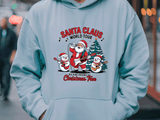 Light blue hoodie with Santa Claus and snowman design on a blurred street background