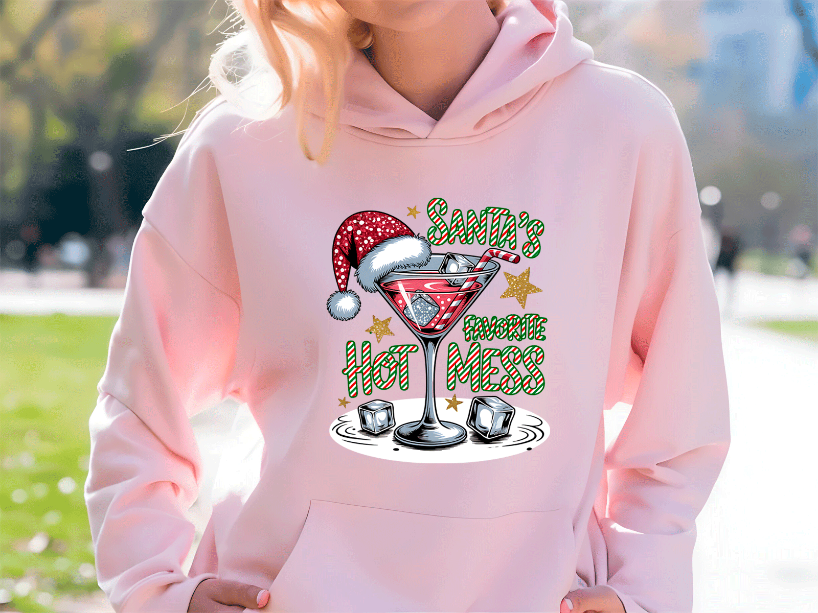 Person wearing a pink hoodie with a Christmas-themed design outdoors.