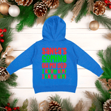 Blue hoodie with colorful text on a wooden surface surrounded by Christmas decorations