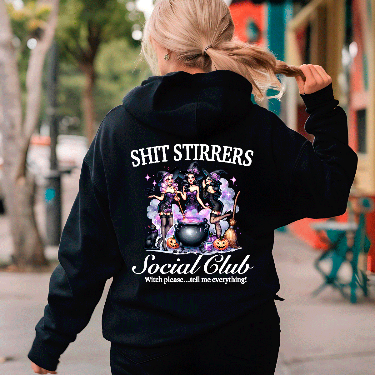 Person wearing a black hoodie with Halloween-themed design and text.