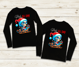 Two black long-sleeve shirts with a colorful graphic design on a wooden surface
