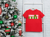 Red t-shirt with 'SMILING IS MY FAVORITE' text next to a decorated Christmas tree on a white brick wall.