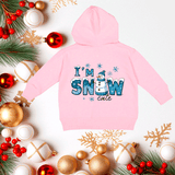 Pink hoodie with 'I'm Snow Cute' text on a festive background with Christmas decorations.