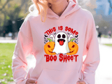 Person wearing a pink hoodie with Halloween-themed design outdoors
