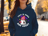 Person wearing a navy blue hoodie with Halloween-themed design outdoors.
