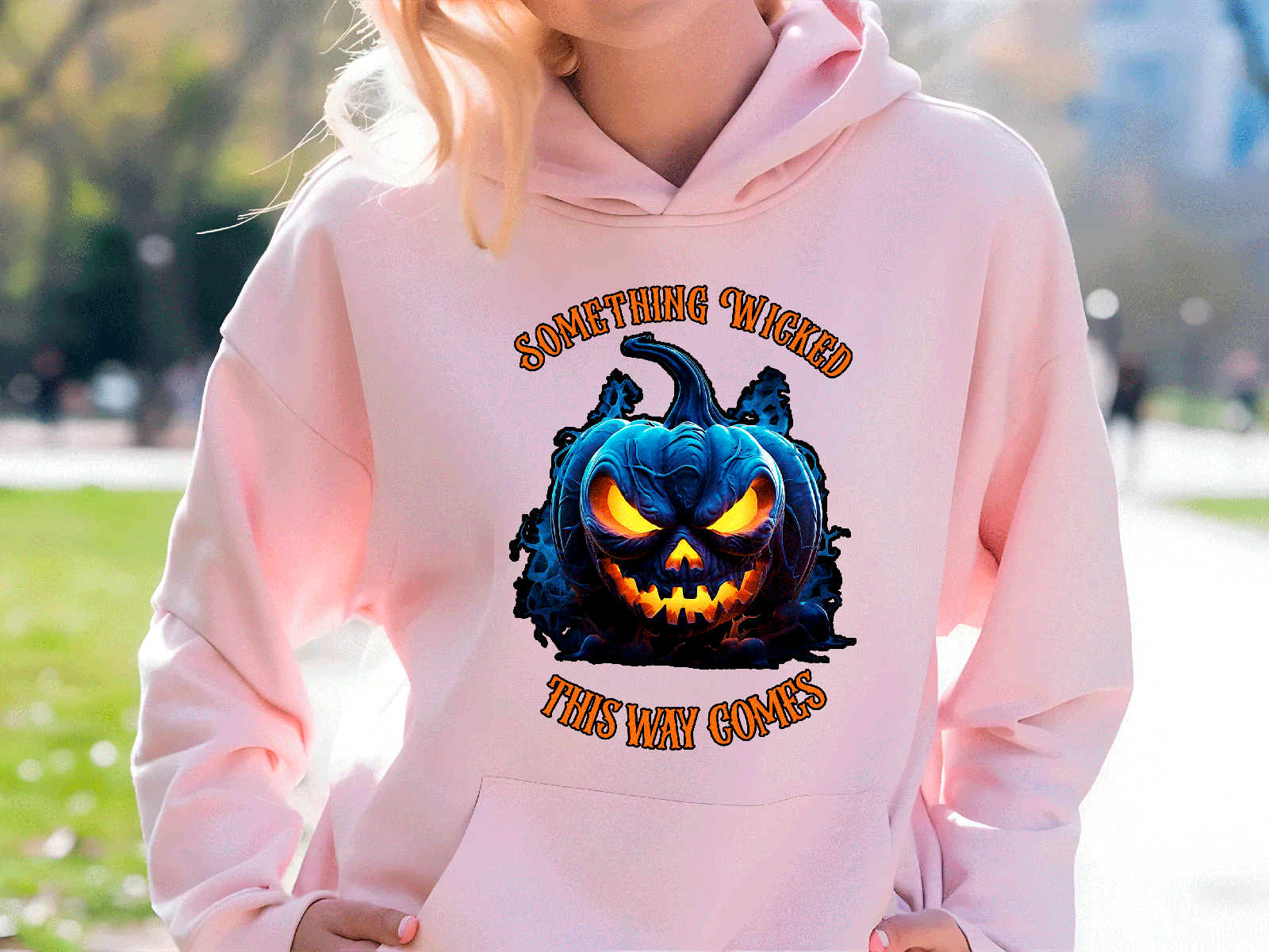 pink hoodie with halloween graphic with a park background