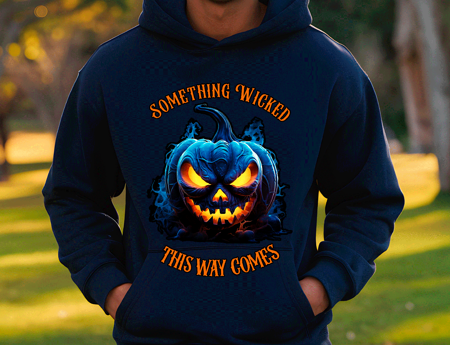 Person wearing a navy hoodie with a pumpkin graphic and text in an outdoor setting