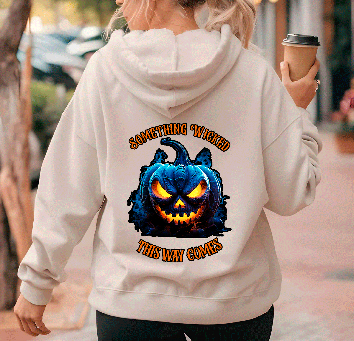 Person wearing a hoodie with a Halloween-themed design and text.