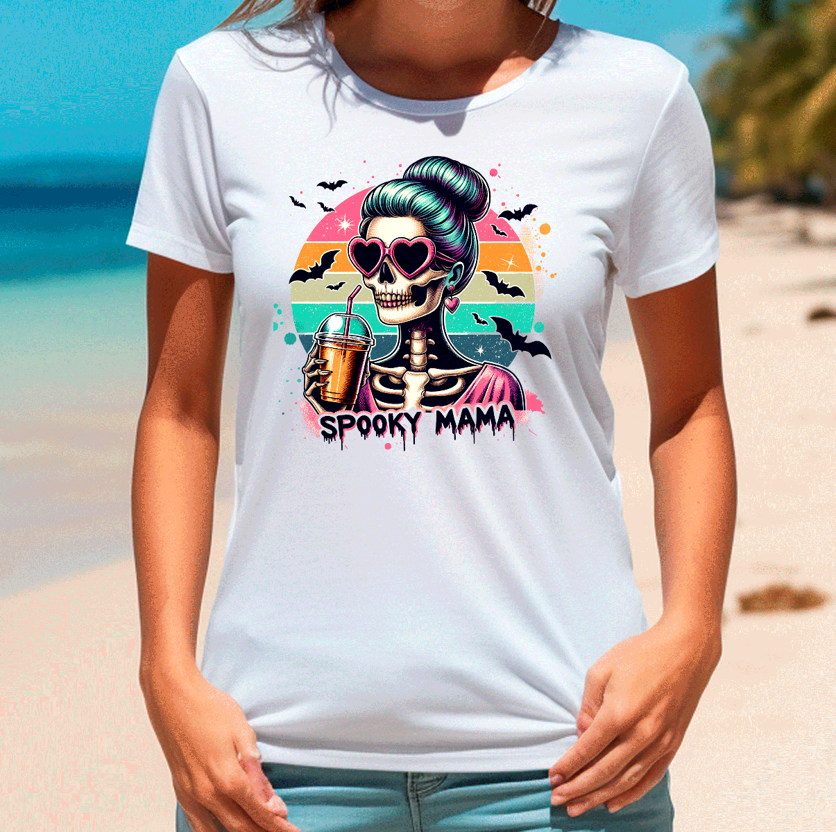 Person wearing a white t-shirt with a colorful graphic design on a beach.