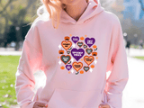 Person wearing a pink hoodie with Halloween-themed designs outdoors.