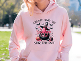 Person wearing a pink hoodie with Halloween-themed design outdoors.