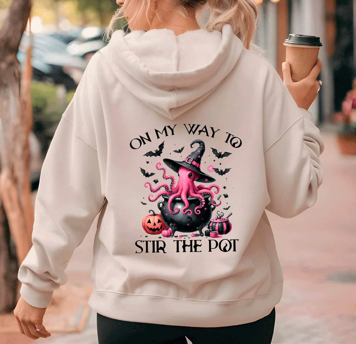 Person wearing a hoodie with a Halloween-themed design and text.