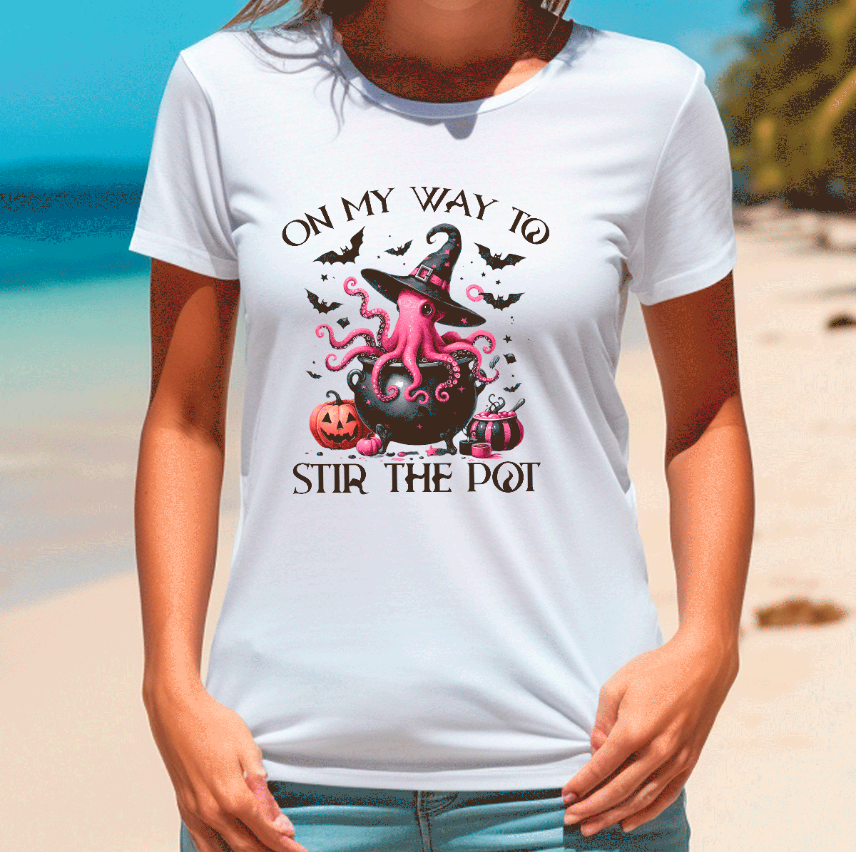 Person wearing a white t-shirt with Halloween-themed design on a beach.