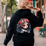 Person wearing a black hoodie with a colorful skull design on the back, walking outdoors.