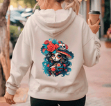 Person wearing a hoodie with a colorful skull design on the back, holding a coffee cup.