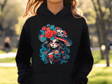 Person wearing a black hoodie with a colorful skull and floral design outdoors.